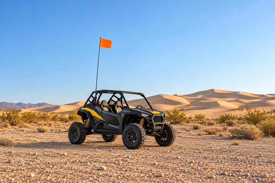 Conceptual parked charcoal and yellow UTV with a tall mast and orange safety flag near desert dunes.